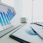Business documents and tablet displaying a graph on a desk.