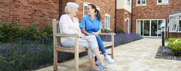 Care home resident and carer outside a residential care facility, illustrating commercial mortgage funding