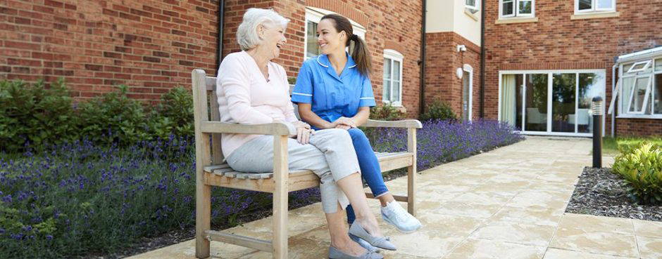 Care home resident and carer outside a residential care facility, illustrating commercial mortgage funding